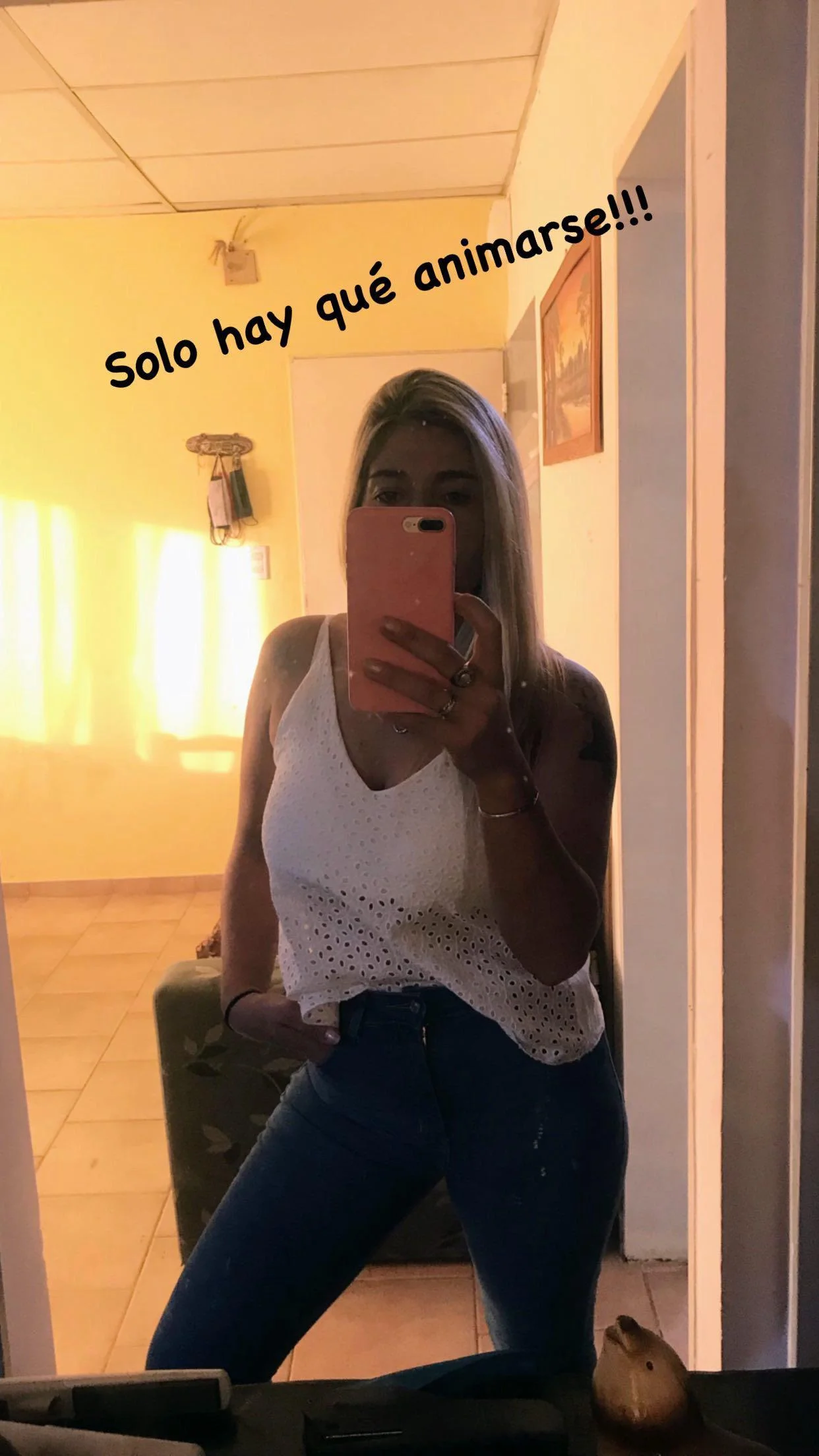 Una mujer joven se toma una selfie en el espejo, mostrando su atuendo y la frase motivacional "Solo hay que animarse!!!" escrita en la pared