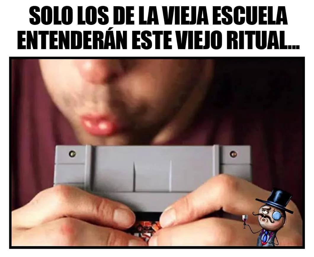 Un hombre soplando un cartucho de videojuego antiguo, con el texto 'SOLO LOS DE LA VIEJA ESCUELA ENTENDERÁN ESTE VIEJO RITUAL...' y un meme